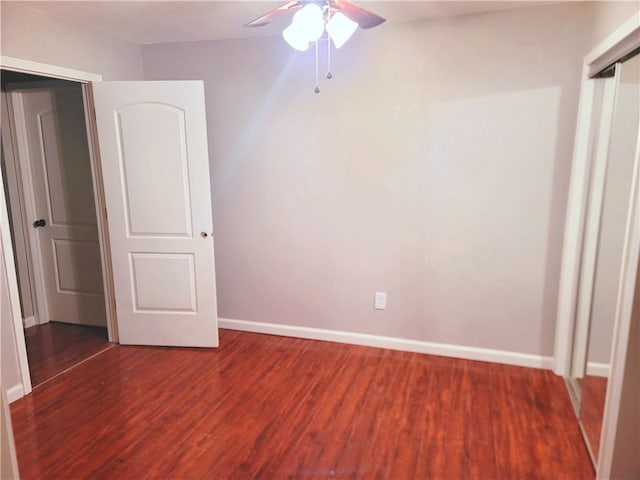 unfurnished room with dark hardwood / wood-style flooring and ceiling fan