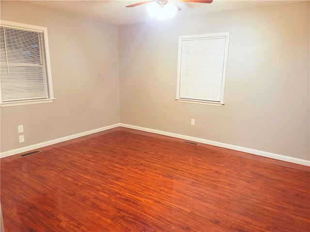 empty room featuring dark hardwood / wood-style flooring and ceiling fan