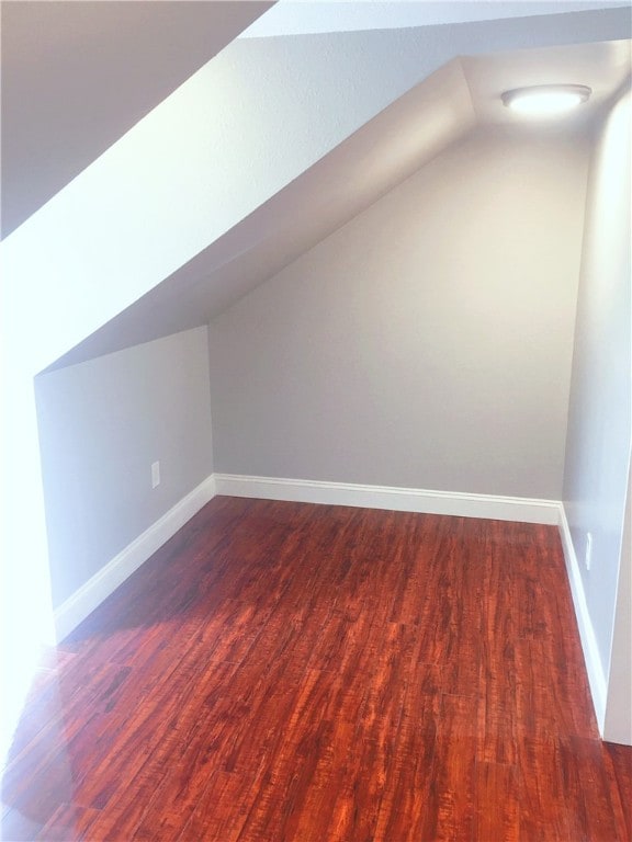 additional living space with lofted ceiling and dark wood-type flooring