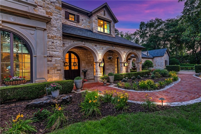 exterior entry at dusk featuring french doors