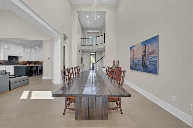 dining area with a notable chandelier and a high ceiling