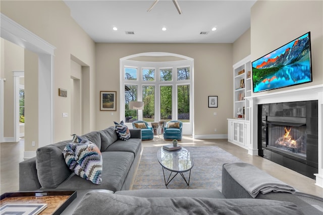 living room with built in shelves and a tiled fireplace