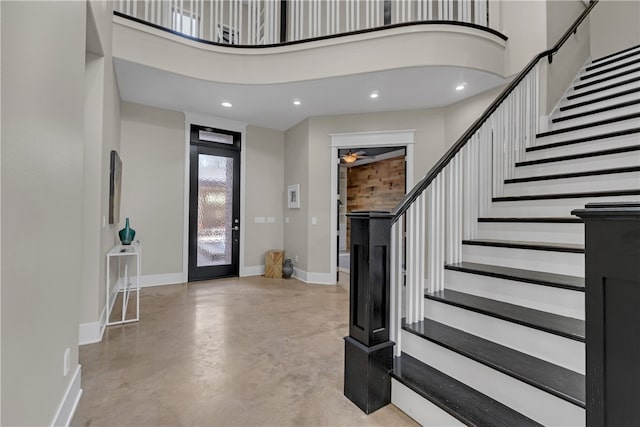 entrance foyer with ceiling fan and a towering ceiling