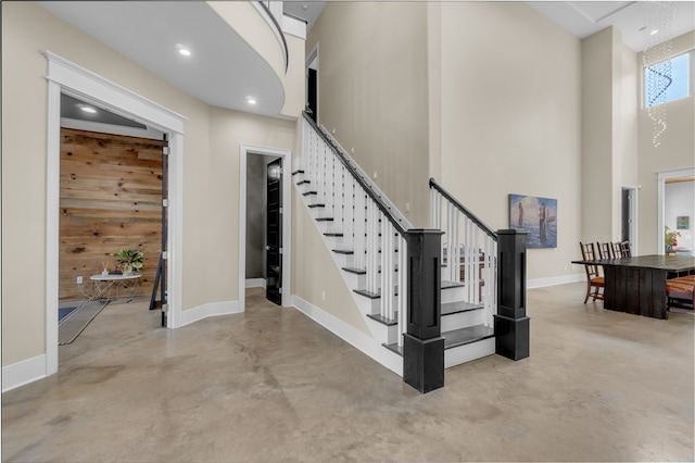 stairs featuring a high ceiling and wood walls