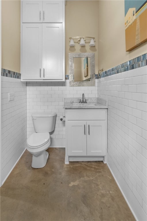 bathroom with vanity, toilet, and concrete flooring