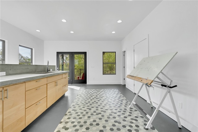 kitchen featuring sink, light brown cabinets, french doors, and light stone counters