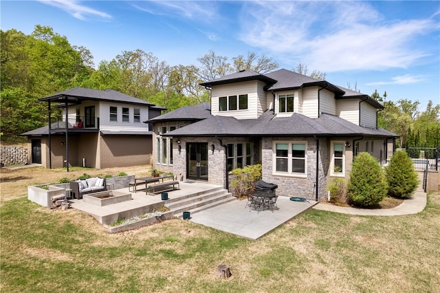 rear view of house with a patio area, an outdoor living space, and a lawn