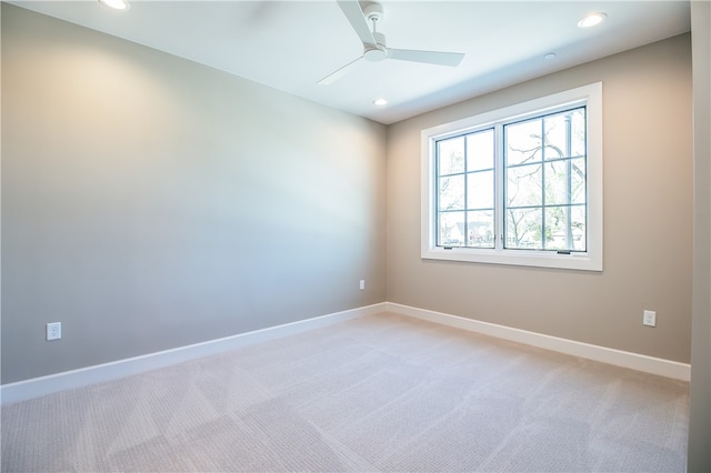 empty room featuring light colored carpet and ceiling fan