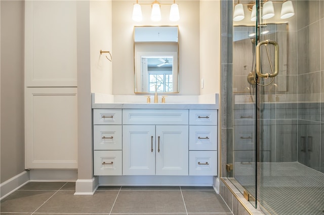 bathroom with tile floors, vanity, and a shower with door