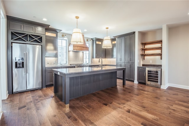 kitchen with wine cooler, hanging light fixtures, dark hardwood / wood-style flooring, appliances with stainless steel finishes, and tasteful backsplash