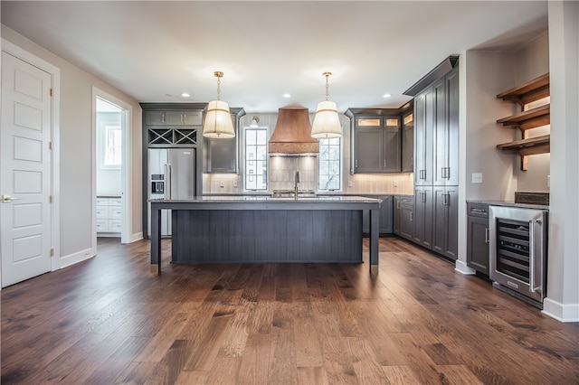 kitchen with pendant lighting, dark wood-type flooring, and beverage cooler