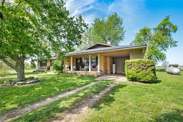 rear view of house featuring a carport and a yard