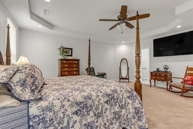 carpeted bedroom featuring ceiling fan and a tray ceiling