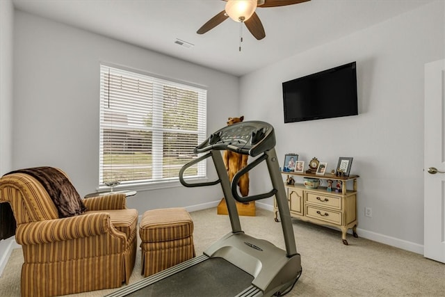 exercise area featuring light colored carpet and ceiling fan