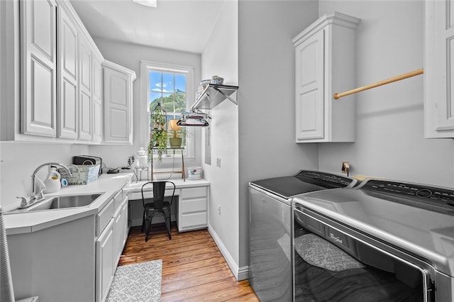 laundry room with independent washer and dryer, light hardwood / wood-style floors, cabinets, and sink