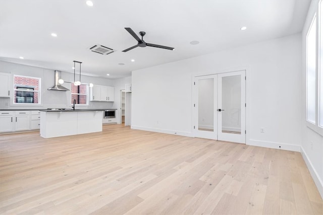 interior space with light hardwood / wood-style floors, ceiling fan, and sink