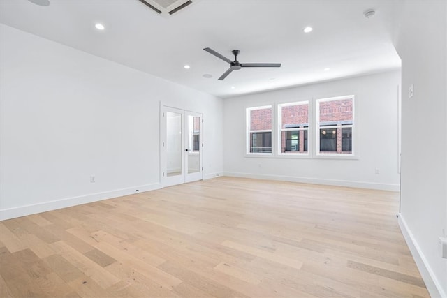 empty room with ceiling fan and light hardwood / wood-style flooring