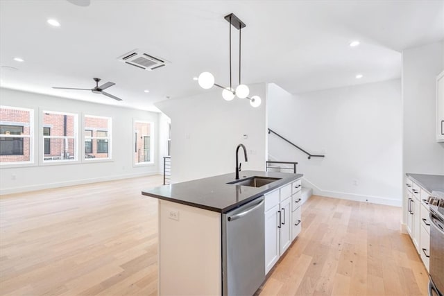 kitchen featuring sink, dishwasher, a kitchen island with sink, and light hardwood / wood-style flooring