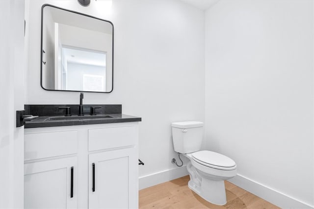 bathroom featuring wood-type flooring, vanity, and toilet