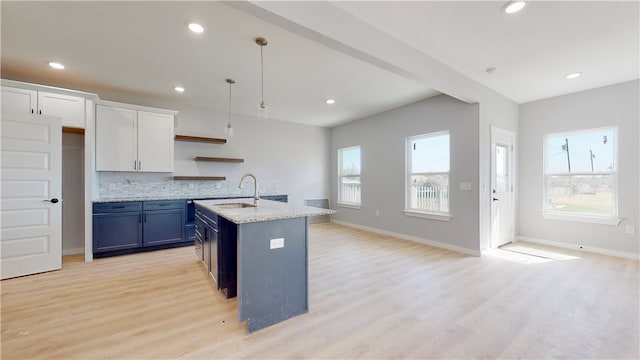 kitchen with decorative light fixtures, white cabinets, light wood-type flooring, backsplash, and blue cabinets