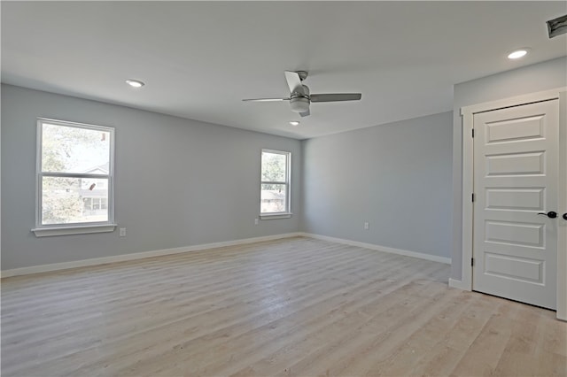 unfurnished room with light hardwood / wood-style flooring, a wealth of natural light, and ceiling fan