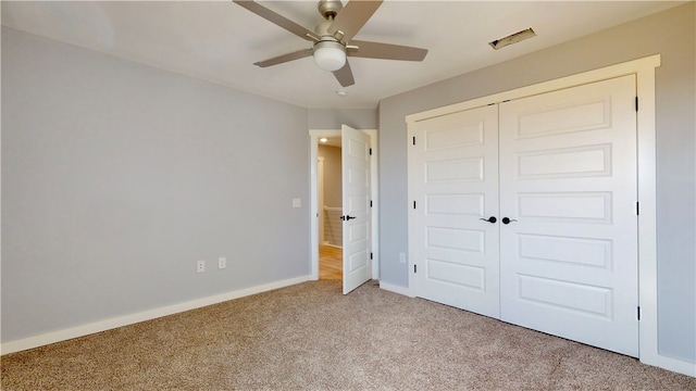 unfurnished bedroom with light colored carpet, ceiling fan, and a closet