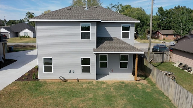 back of house with a patio area and a lawn