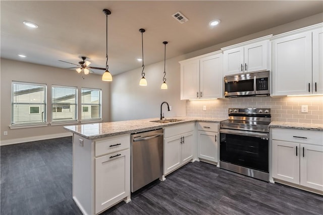 kitchen with stainless steel appliances, pendant lighting, white cabinets, and kitchen peninsula