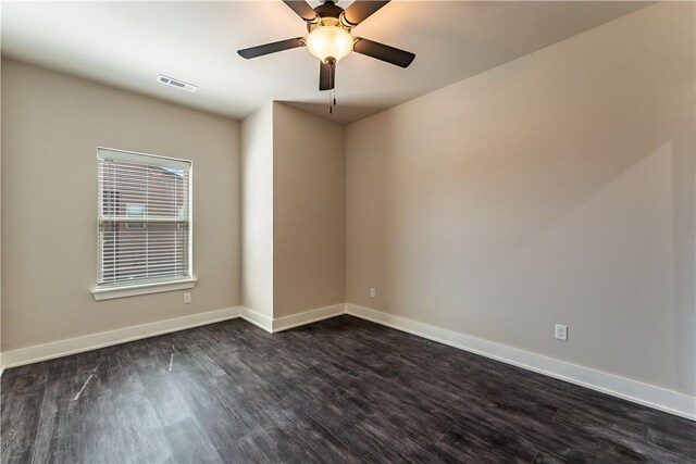 empty room with ceiling fan and dark hardwood / wood-style flooring