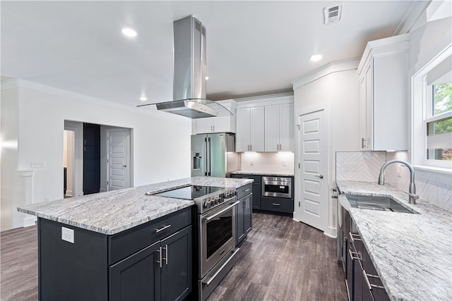 kitchen featuring island exhaust hood, a center island, white cabinets, and stainless steel appliances