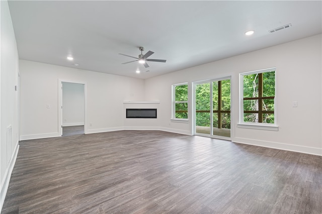 unfurnished living room featuring ceiling fan and dark wood-type flooring