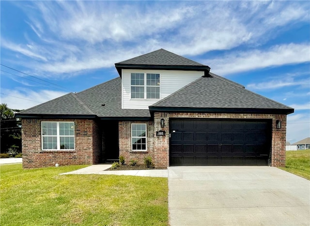 view of front of home with a front yard and a garage