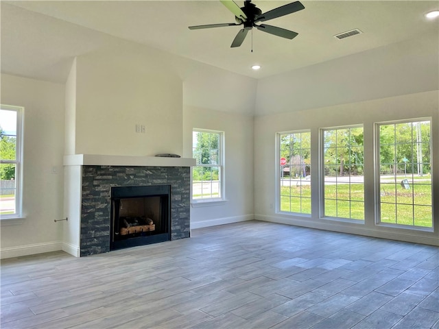 unfurnished living room with plenty of natural light, a fireplace, and light hardwood / wood-style flooring