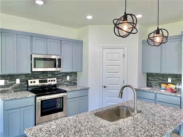 kitchen with decorative light fixtures, sink, backsplash, and stainless steel appliances