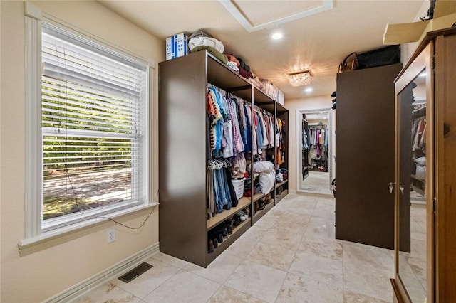 spacious closet with light tile patterned floors