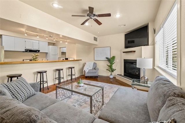 living room with ceiling fan and dark hardwood / wood-style floors