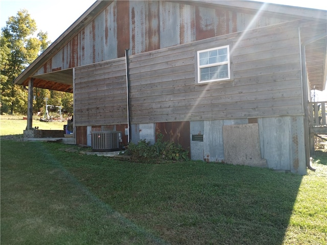 view of property exterior featuring a lawn and central AC