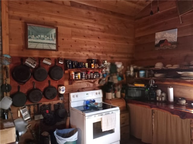 kitchen with white electric stove and wood walls