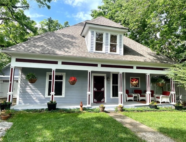 view of front of home featuring a porch, a garage, and a front lawn