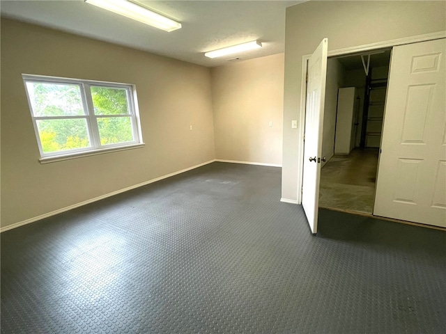 spare room featuring dark carpet