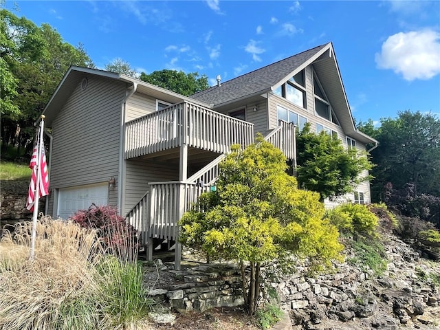 view of home's exterior with a wooden deck and a garage