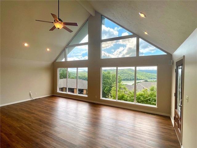 unfurnished living room with high vaulted ceiling, beam ceiling, and dark wood-type flooring