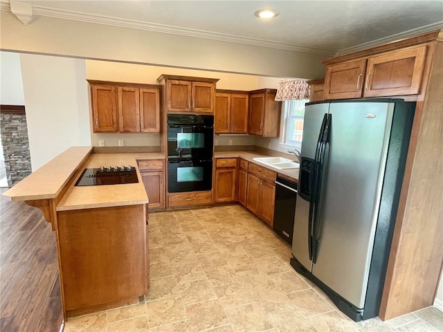 kitchen with crown molding, sink, kitchen peninsula, and black appliances