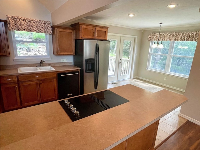 kitchen with black appliances, light hardwood / wood-style floors, a healthy amount of sunlight, and sink