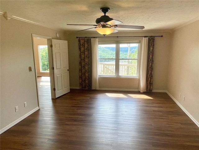 empty room featuring ceiling fan, plenty of natural light, and dark wood-type flooring