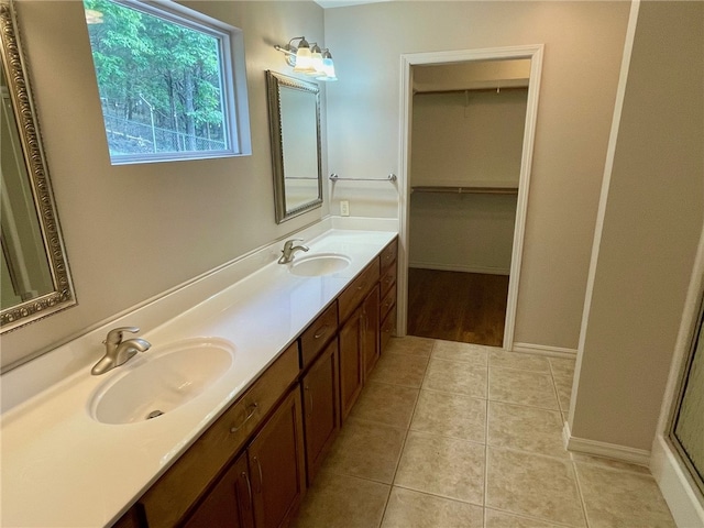 bathroom featuring tile patterned floors, a shower with door, and vanity