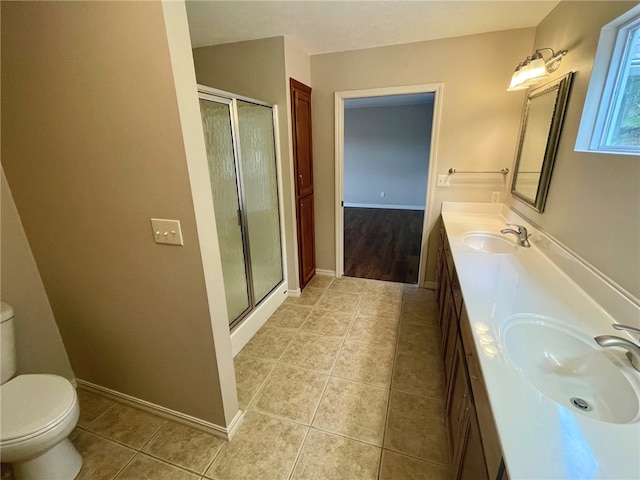 bathroom with tile patterned floors, a shower with shower door, vanity, and toilet