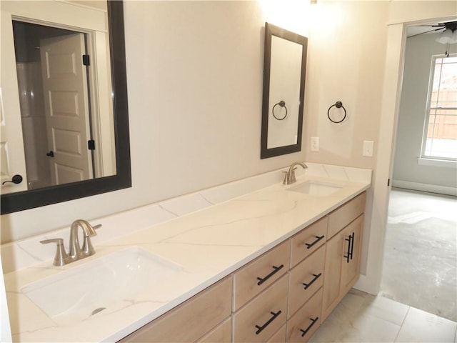 full bathroom with double vanity, a ceiling fan, and a sink