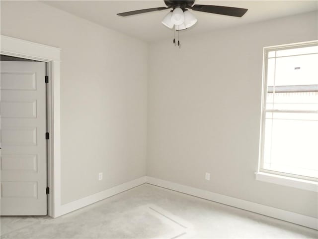 unfurnished room featuring a ceiling fan and baseboards