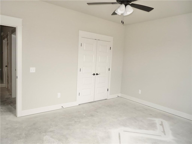 unfurnished bedroom featuring ceiling fan, concrete floors, a closet, and baseboards